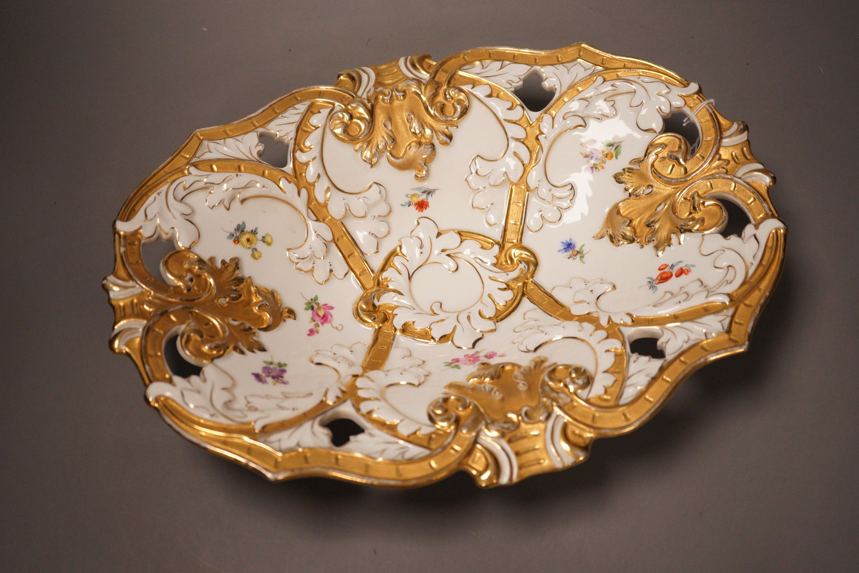 An early 20th century Meissen two handled white and gilt floral oval dish, 32cm